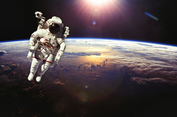 فضانوردان در فضای بیرونی بالای زمین هنگام غروب آفتاب عناصر