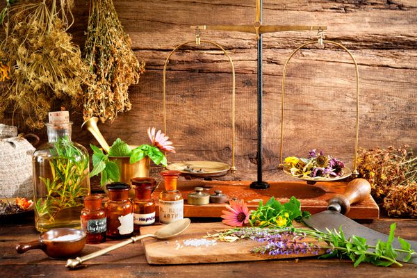 داروهای طبیعی باستانی گیاهی ویال و مقیاس در پس زمینه چوبی