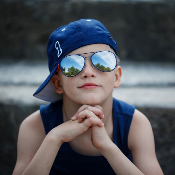 پرتره پسر کوچک شیک در عینک آفتابی و کلاه چیلدو
