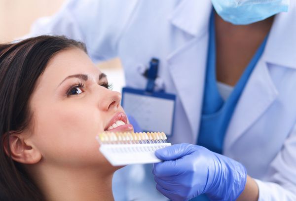 دندانپزشک زن که در دندان بیماران خود کار می کند