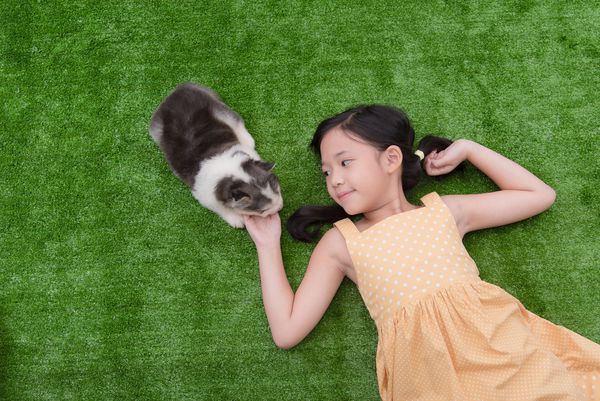 دختر ناز آسیایی که با توله سگ خود دراز کشیده است