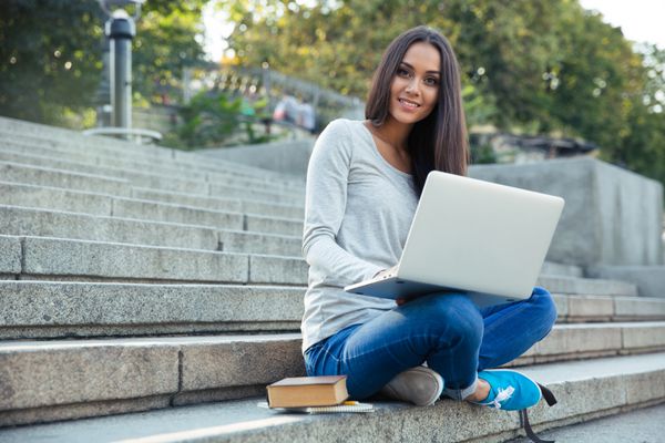 دانشجوی دختر با استفاده از رایانه لپ تاپ در فضای باز