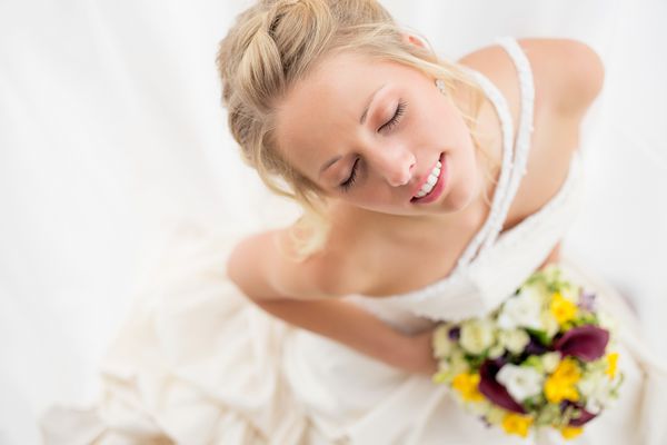 عروس مبارک دسته گل عروسی خود را نگه می دارد