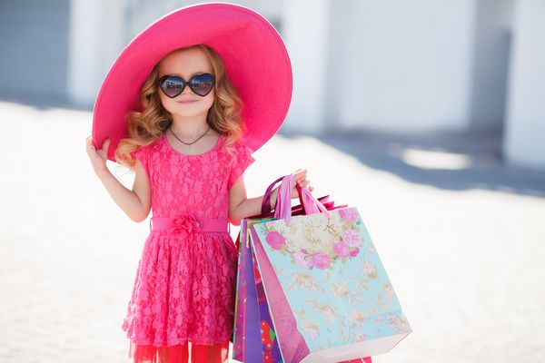 دخترک مد روز در یک کلاه با کیسه های خرید