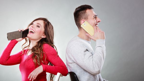 زن و شوهر جوان مبارک که در تلفن های همراه صحبت می کنند