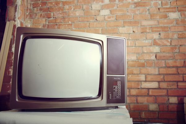 صفحه سفید آنالوگ قدیمی تلویزیون در یک انبار آجری