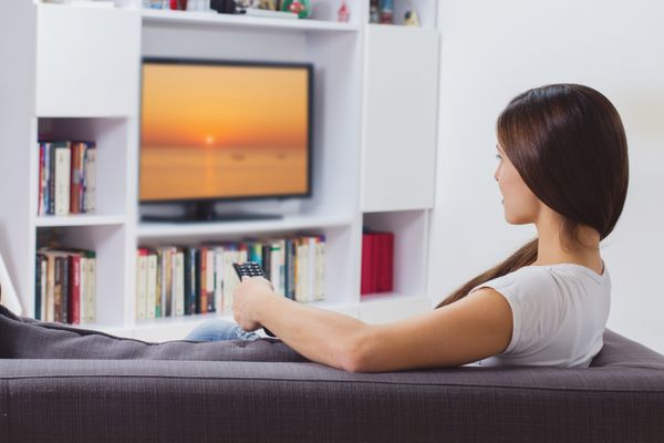 زن در حال تماشای تلویزیون در خانه