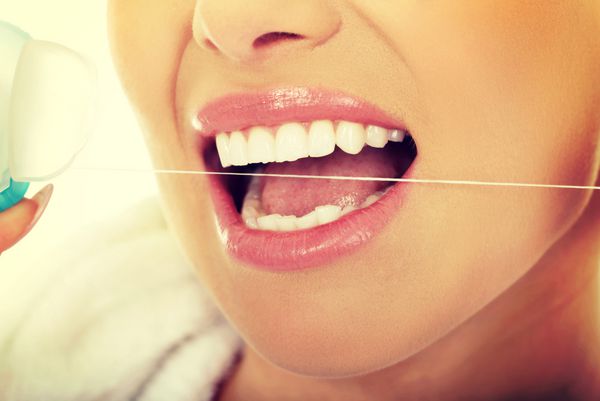 زنی که از نخ دندان استفاده می کند