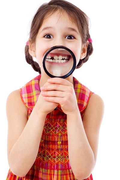 دختر خنده دار نشان دادن دندان از طریق ذره بین جدا شده بر روی سفید