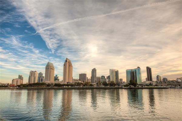 آسمان سان دیگو کالیفرنیا در یک روز آفتابی روشن با بازتاب ساختمان در آب و آسمانی ابری این یک تصویر با دامنه دینامیکی بالا است خط آسمان سان دیگو