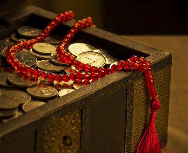 سکه های درهم امارات در یک صندوق عقب و تسبیح