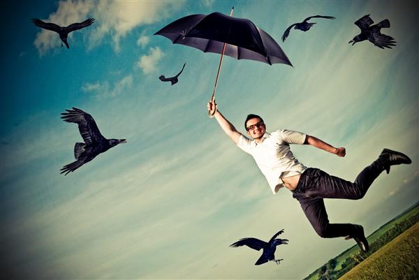 مرد جوانی که روی چترها پرواز می کند