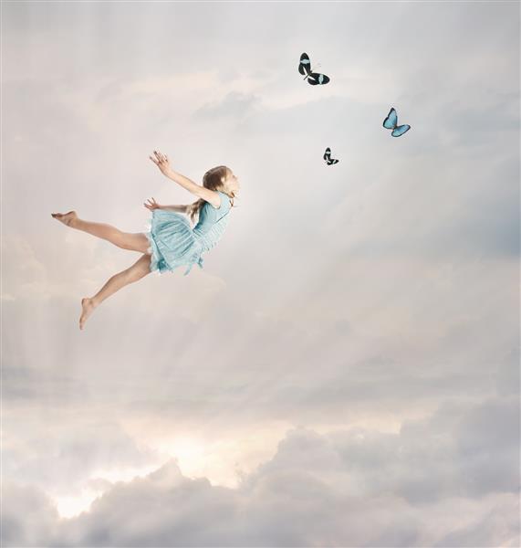 دختر کوچک بلوند در حال گرگ و میش با پروانه ها پرواز می کند