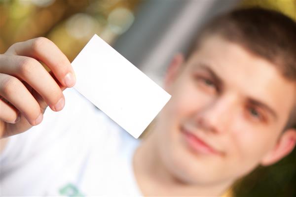 مرد جوانی که کارت ویزیت خالی در دست دارد