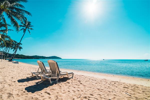 ساحل و دریا گرمسیری زیبا با صندلی در آسمان آبی برای سفر و تعطیلات