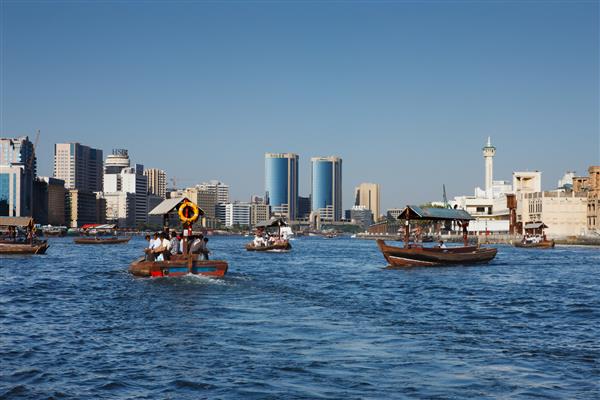 امارات متحده عربی - نمای آسمان نهر دبی با فعالیت تاکسی قایق سنتی نهر در حال تقسیم شهر به دو بخش اصلی است - دیره و بر دبی