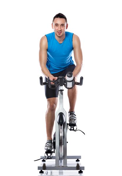 مرد جوان در حال ورزش با دوچرخه کلاس ورزش در حال چرخش