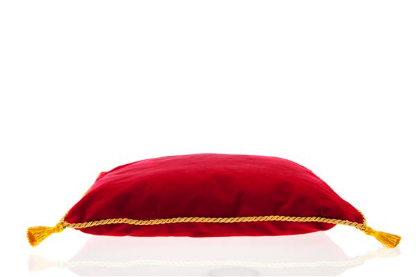بالش مخملی قرمز سلطنتی با طناب طلایی که روی زمینه سفید جدا شده است