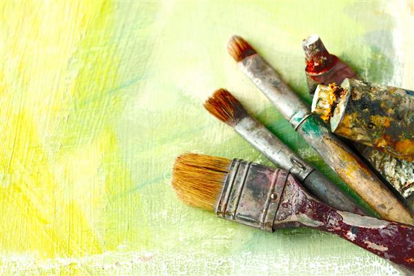 هنرمندان جذاب بر روی زمینه هنری انتزاعی مسواک می زنند و لوله ها را رنگ می کنند