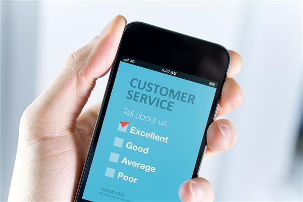 دست آقایان تلفن همراه مدرنی را با فرم نظرسنجی خدمات مشتری روی صفحه در دست دارد علامت قرمز در انتخاب عالی نشان دهنده رضایت مشتری است
