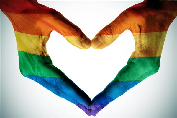 دستان مرد به عنوان پرچم رنگین کمان که قلب را شکل می دهد نمادی از عشق همجنسگرایان است