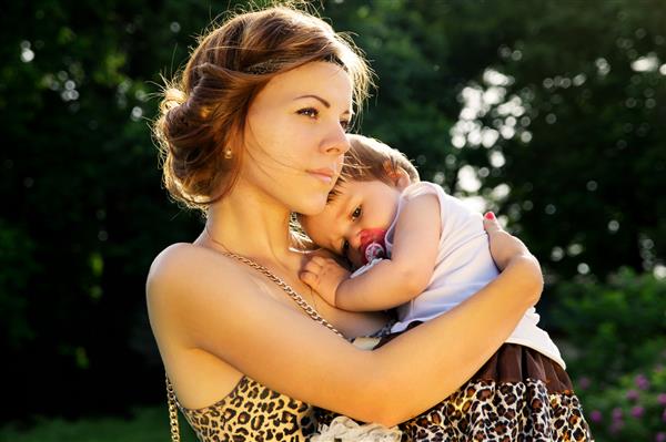محافظت مادر هنگام غروب آفتاب کودک را بغل می کند