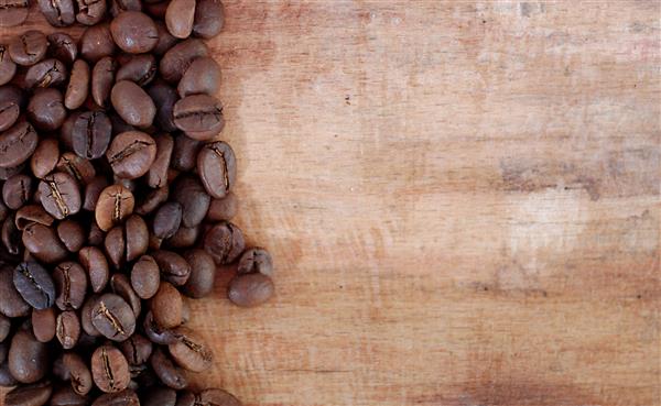دانه های قهوه در زمینه چوبی