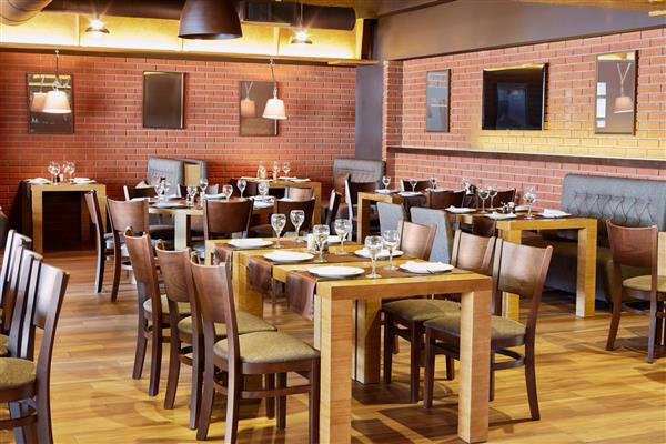 اتاق رستوران با مبلمان چوبی و دیوارهای آجر قرمز