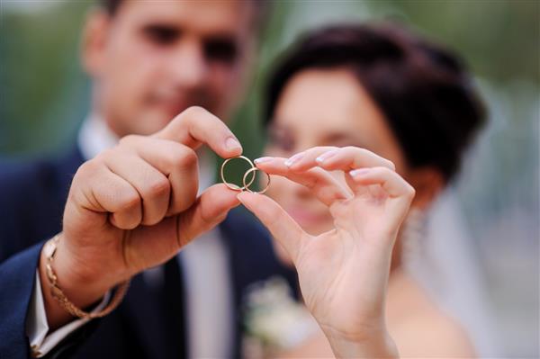 عروس و دامادی که در یک حلقه دست یکدیگر را گرفته اند