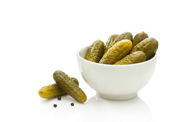 خیار شور در یک کاسه سفید روی زمینه چوبی قرار دهید 1556501