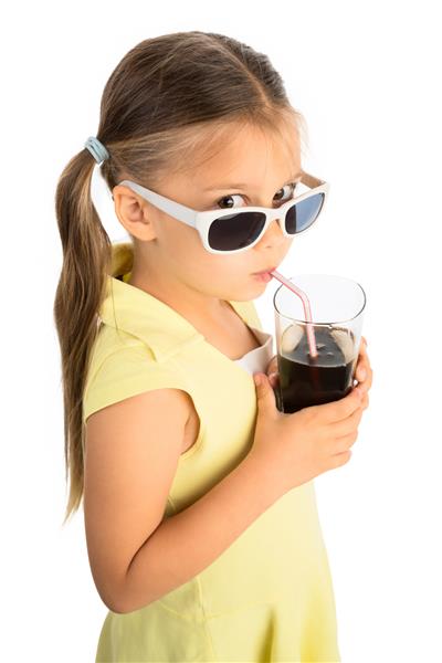 دختر کوچکی که از طریق نی نوشیدنی کولا می نوشد و با شک و تردید به تماشاگر نگاه می کند از طریق عینک آفتابی از نقطه نظر بالا دیده می شود