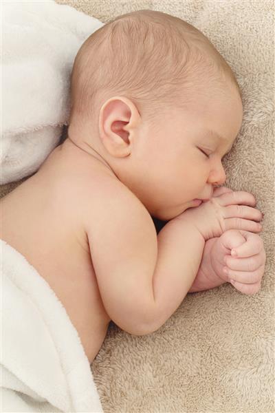 پرتره خواب نوزاد تازه متولد شده روی پوشش بژ