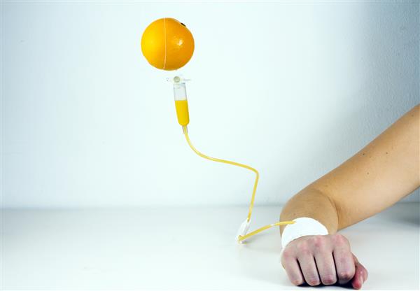 میوه نارنج به قطره IV در بازو متصل می شود تزریق ویتامین استودیو شات
