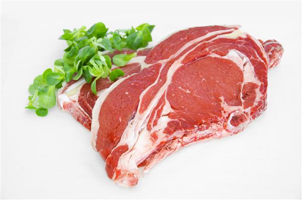 تکه های گوشت خام استیک گوشت گاو بر روی سفید