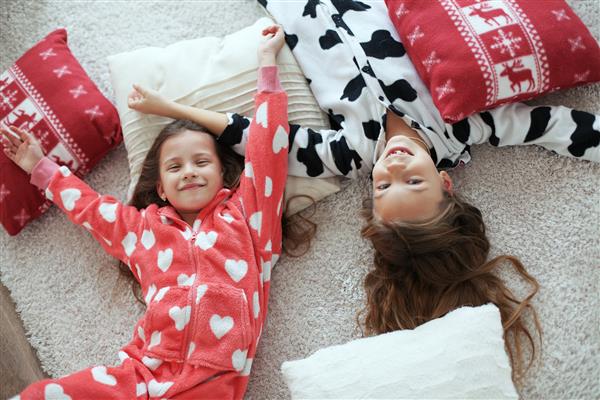 کودکان با لباس خواب گرم و نرم در خانه بازی می کنند
