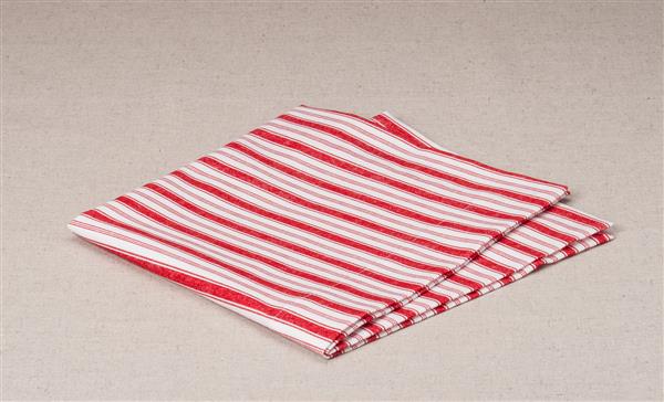 دستمال تاشده سفید و قرمز در زمینه پارچه های طبیعی