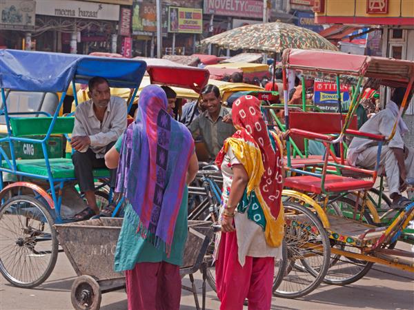 دهلی هند صاحبان موتورهای چرخی که با مشتریان بالقوه در منطقه در شهر قدیمی گفتگو می کنند