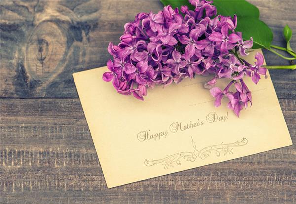 گلهای بنفش در زمینه چوبی کارت تبریک با متن نمونه روز مادر مبارک سبک برش خورده تصویر