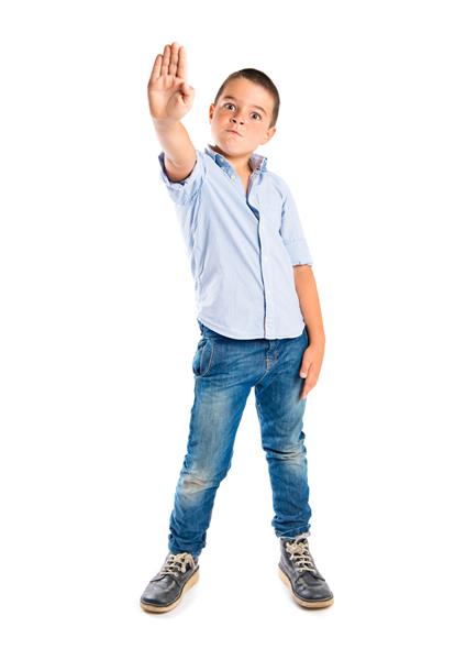 کودک جوان در حال انجام علامت ایست روی پس زمینه سفید است