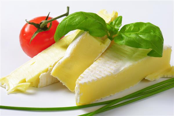 تکه های پنیر شیر گاو همراه با گیاهان و گوجه فرنگی