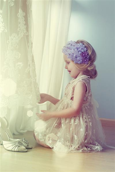 دختر کوچک لباس عروس را لمس می کند