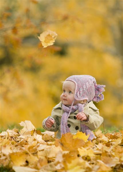 کودک در برگهای پاییز