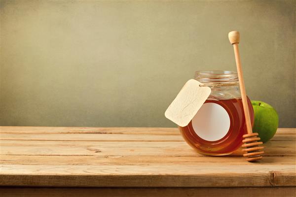 عسل و سیب روی میز چوبی با فضای کپی