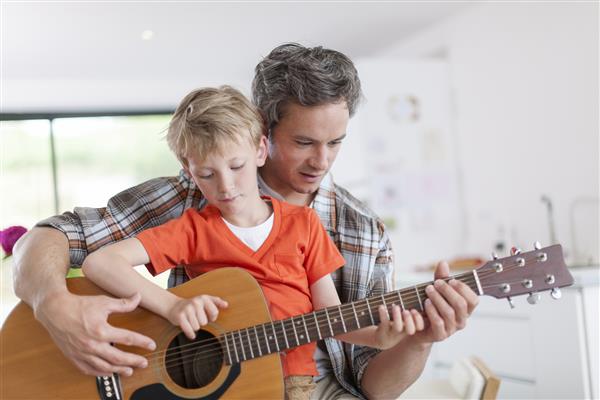 پدر پسر خود را برای نواختن گیتار یاد می گیرد