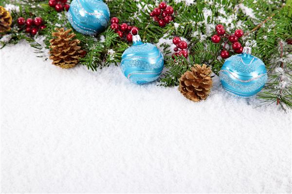مرز کریسمس با تزئینات مخروط های کاج و درخت کریسمس روی برف ها