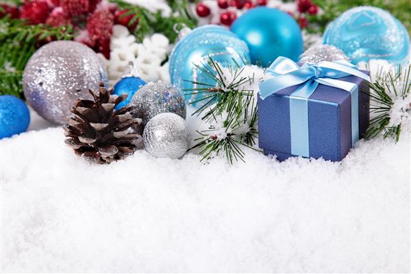 مرز کریسمس با تزئینات مخروط کاج و هدیه روی برف