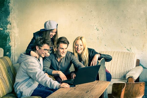 گروهی از بهترین دوستان جوان هیپستر با لپ تاپ رایانه در مکان جایگزین شهری مفهوم دوستی و تفریح ​​با گرایش ها و فناوری های جدید اتصال بی سیم و تعامل اینترنت وب