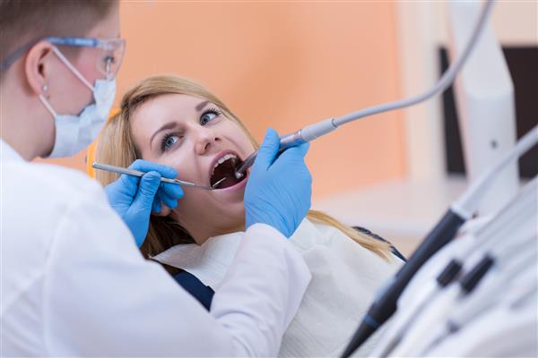 دندانپزشکی دندان زن جوان را سوراخ می کند