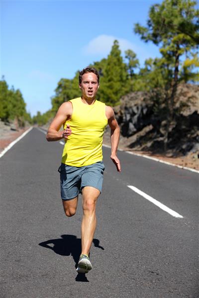 مرد دونده در حال دویدن سرعت برای رسیدن به موفقیت دونده مرد ورزشکار با سرعت بالا تمرین می کند دوومیدانی جاده جنگلی با عضله متناسب