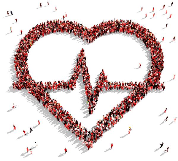 گروه بزرگی از افراد با لباس قرمز که از بالا دیده می شوند به شکل نماد نبض قلب جمع شده اند